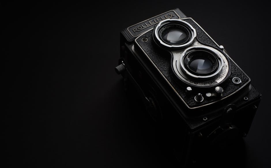 A striking close-up of a vintage Rolleiflex camera against a stark black background.